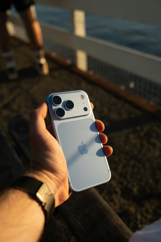 Silver iPhone Pro held in golden evening light
